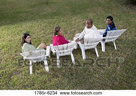 Rear view of four people in lawn chairs in backyard View Large Photo Image Picture - Rear view of four people in lawn chairs in backyard. Fotosearch