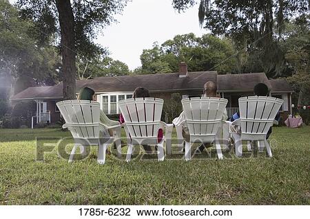 Rear view of four people in lawn chairs in backyard View Large Photo Image Stock Image - Rear view of four people in lawn chairs in backyard. Fotosearch