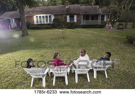 Rear view of four people in lawn chairs in backyard View Large Photo Image Stock Image - Rear view of four people in lawn chairs in backyard. Fotosearch