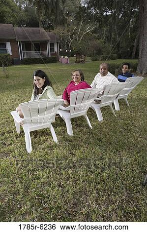 Rear view of four people in lawn chairs in backyard View Large Photo Image Stock Photograph - Rear view of four people in lawn chairs in backyard. Fotosearch