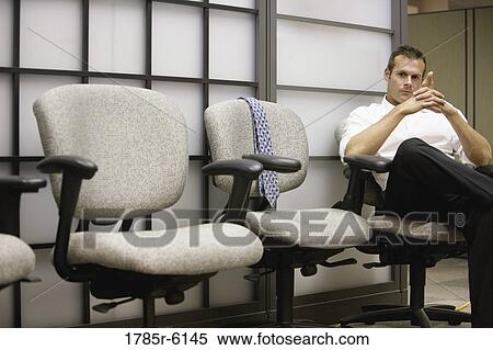 Relaxed and casual businessman sitting on chair View Large Photo Image Stock Photography - Relaxed and casual businessman sitting on chair. Fotosearch