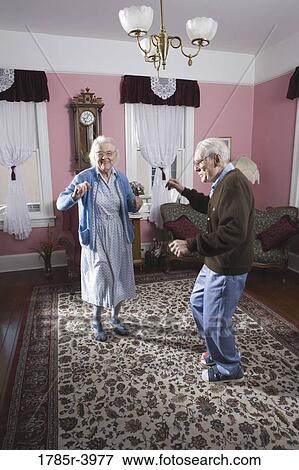 Senior couple dancing in living room View Large Photo Image Stock Photo - Senior couple dancing in living room. Fotosearch