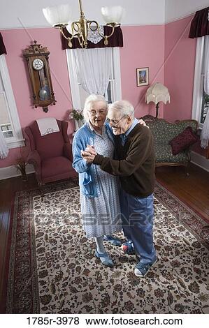 Stock Photo - Senior couple dancing in living room. Fotosearch