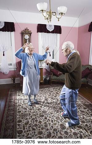 Senior couple dancing in living room View Large Photo Image Stock Photograph - Senior couple dancing in living room. Fotosearch