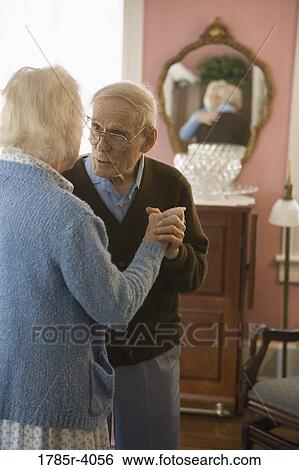 Stock Photograph - Senior couple dancing in living room. Fotosearch