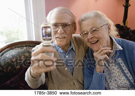 Senior couple photographing themselves with cell phone camera View Large Photo Image Stock Image - Senior couple photographing themselves with cell phone camera. Fotosearch
