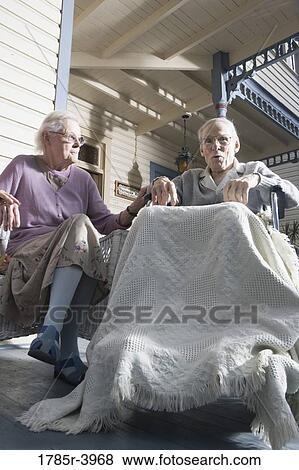 Senior couple sitting together on front porch View Large Photo Image Stock Photo - Senior couple sitting together on front porch. Fotosearch