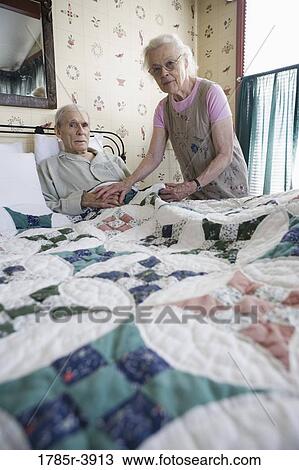 Senior woman affectionately tending to bedridden senior man View Large Photo Image Stock Image - Senior woman affectionately tending to bedridden senior man. Fotosearch