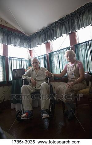 Senior woman sitting next to feeble senior man in wheelchair in bedroom View Large Photo Image Stock Photography - Senior woman sitting next to feeble senior man in wheelchair in bedroom. Fotosearch