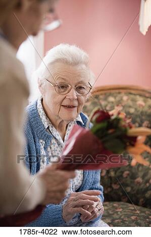Senior woman surprised by bouquet of flowers offered by senior man View Large Photo Image Stock Image - Senior woman surprised by bouquet of flowers offered by senior man. Fotosearch
