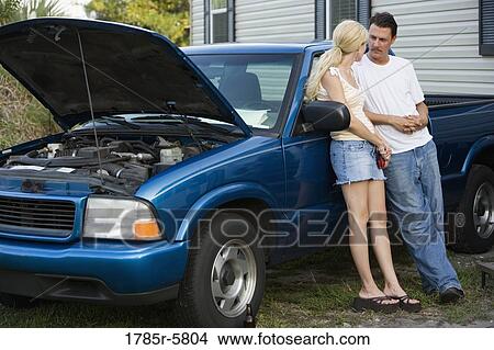 Serious couple conversing while leaning against old truck, in front of trailer home View Large Photo Image Picture - Serious couple conversing while leaning against old truck, in front of trailer home. Fotosearch