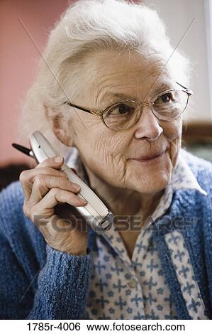 Stock Photograph - Smiling senior woman talking on cordless phone. Fotosearch