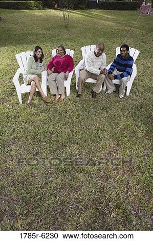 Stock Image - Son and his girlfriend relaxing with his parents backyard. Fotosearch