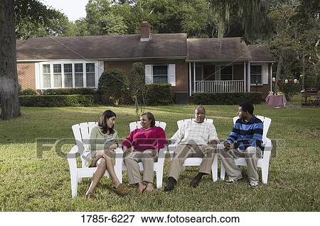 Stock Photo - Son and his girlfriend relaxing with his parents backyard. Fotosearch