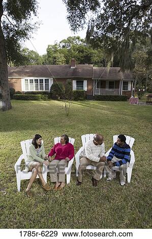 Stock Photo - Son and his girlfriend relaxing with his parents backyard. Fotosearch