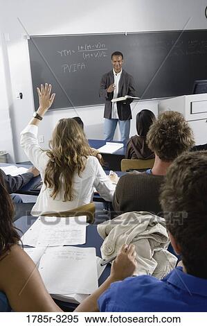 Stock Photography - Student raising hand in the classroom. Fotosearch