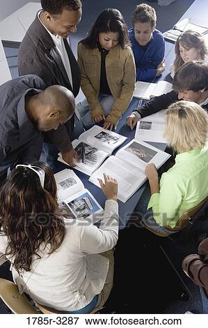 Stock Photo - Students and teacher reading books in the classroom. Fotosearch