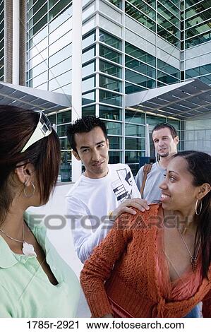 Students hanging out and socializing in front of a building View Large Photo Image Stock Image - Students hanging out and socializing in front of a building. Fotosearch