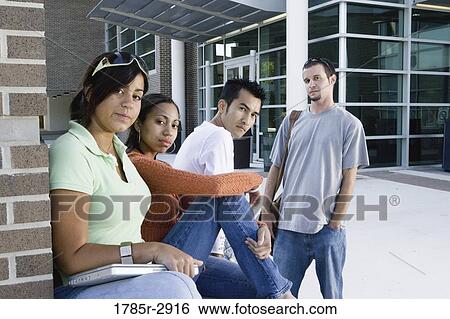 Stock Photograph - Students hanging out and socializing in front of a building. Fotosearch