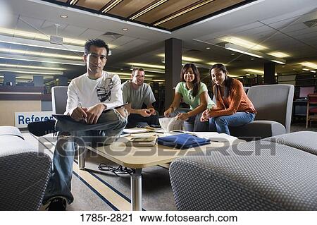 Stock Image - Students in library sitting on sofas studying. Fotosearch