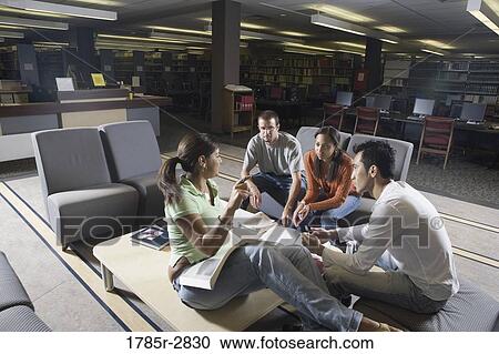 Stock Image - Students in library sitting on sofas studying. Fotosearch