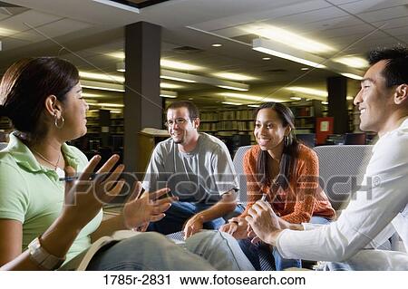 Stock Image - Students in library sitting on sofas studying. Fotosearch