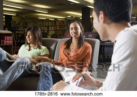 Stock Photograph - Students in library sitting on sofas studying. Fotosearch
