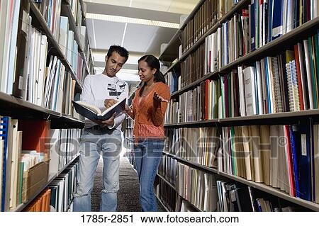 Students in the library looking through book stacks View Large Photo Image Stock Image - Students in the library looking through book stacks. Fotosearch