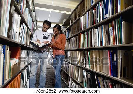 Students in the library looking through book stacks View Large Photo Image Stock Image - Students in the library looking through book stacks. Fotosearch