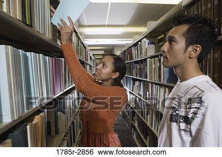 Students in the library looking through book stacks View Large Photo Image Stock Photograph - Students in the library looking through book stacks. Fotosearch