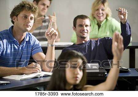 Stock Image - Students raising hands in the classroom. Fotosearch