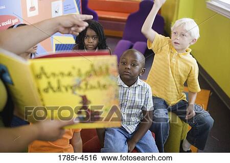 Students sitting in classroom, raising their hands to their teacher View Large Photo Image Stock Photograph - Students sitting in classroom, raising their hands to their teacher. Fotosearch