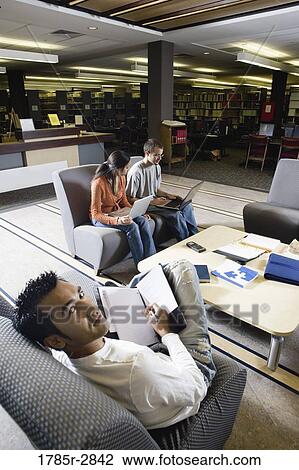Students with laptop computers in library sitting on sofas studying View Large Photo Image Stock Image - Students with laptop computers in library sitting on sofas studying. Fotosearch