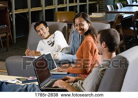 Students with laptop computers in library sitting on sofas studying View Large Photo Image Stock Photo - Students with laptop computers in library sitting on sofas studying. Fotosearch