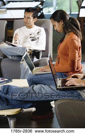 Students with laptop computers in library sitting on sofas studying View Large Photo Image Stock Photograph - Students with laptop computers in library sitting on sofas studying. Fotosearch