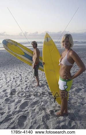 Surfer dude and girl posing on beach at sunrise with surfboards View Large Photo Image Stock Image - Surfer dude and girl posing on beach at sunrise with surfboards. Fotosearch