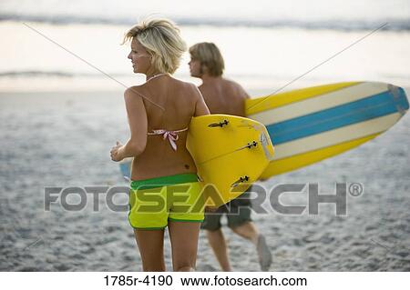 Surfer dude and girl running on beach with surfboards View Large Photo Image Stock Image - Surfer dude and girl running on beach with surfboards. Fotosearch
