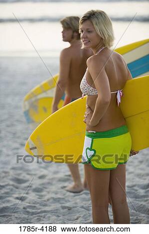 Surfer dude and girl standing on beach with surfboards View Large Photo Image Stock Photo - Surfer dude and girl standing on beach with surfboards. Fotosearch
