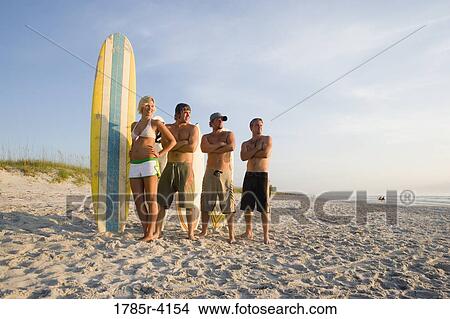 Surfer dudes and girl posing on beach surfboards View Large Photo Image Picture - Surfer dudes and girl posing on beach surfboards. Fotosearch