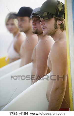 Surfer dudes and girl posing on beach with surfboards View Large Photo Image Picture - Surfer dudes and girl posing on beach with surfboards. Fotosearch