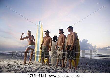 Surfer dudes and girl posing on beach at sunrise with surfboards View Large Photo Image Stock Image - Surfer dudes and girl posing on beach at sunrise with surfboards. Fotosearch