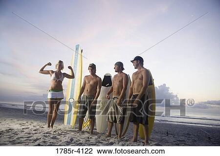 Surfer dudes and girl posing on beach at sunrise with surfboards View Large Photo Image Stock Image - Surfer dudes and girl posing on beach at sunrise with surfboards. Fotosearch