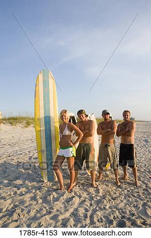 Surfer dudes and girl posing on beach surfboards View Large Photo Image Stock Image - Surfer dudes and girl posing on beach surfboards. Fotosearch