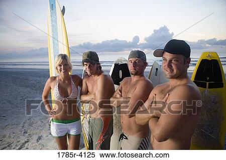 Surfer dudes and girl posing on beach at sunrise with surfboards View Large Photo Image Stock Photography - Surfer dudes and girl posing on beach at sunrise with surfboards. Fotosearch