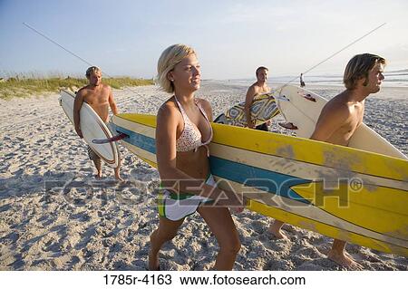 Surfer dudes and girl running towards surf with surfboards View Large Photo Image Stock Image - Surfer dudes and girl running towards surf with surfboards. Fotosearch