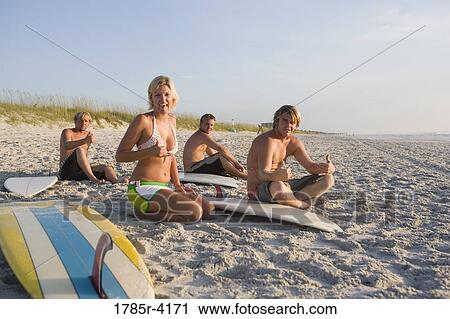 Surfer dudes and girl sitting on beach with surfboards View Large Photo Image Stock Image - Surfer dudes and girl sitting on beach with surfboards. Fotosearch