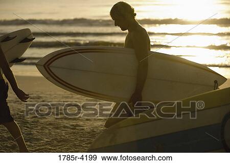 Surfer dudes walking on beach with surfboards View Large Photo Image Stock Photo - Surfer dudes walking on beach with surfboards. Fotosearch