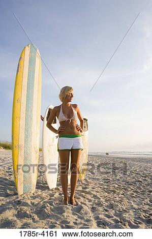 Surfer girl posing on beach with surfboards View Large Photo Image Stock Image - Surfer girl posing on beach with surfboards. Fotosearch