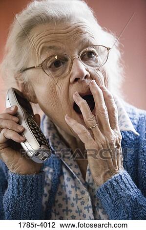 Surprised and unhappy senior woman talking on cordless phone View Large Photo Image Stock Image - Surprised and unhappy senior woman talking on cordless phone. Fotosearch