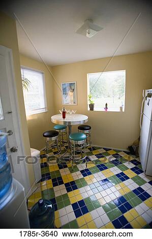 Stock Image - Table and stools arranged in empty kitchen. Fotosearch